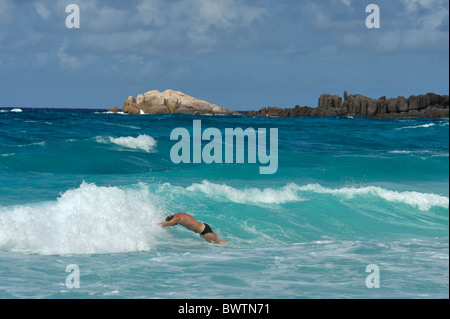 Mann tauchen in das Wasser, Grand Anse, La Digue, Seychellen Stockfoto