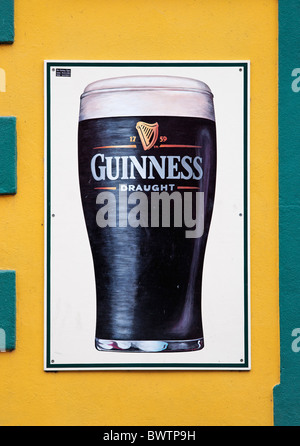Guinness-Schild an der kleinen Brücke Pub Wand, Dingle, County Kerry, Munster, Irland. Zeichen von Mc Closkey Zeichen. Stockfoto