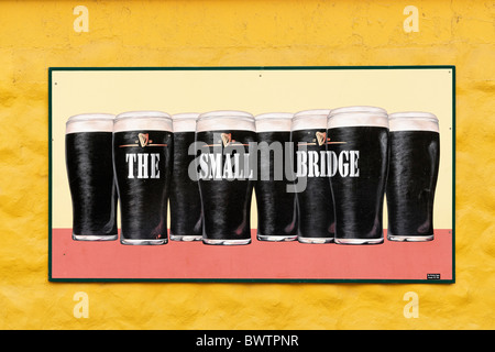 Guinness-Schild an der kleinen Brücke Pub Wand, Dingle, County Kerry, Munster, Irland. Zeichen von Mc Closkey Zeichen. Stockfoto