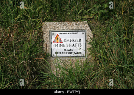 National Trust Schild mit der Aufschrift, dass Gefahr Schächte zu Wanderweg, Cape Cornwall (Bild aus einem öffentlichen Fußweg) beachten Stockfoto