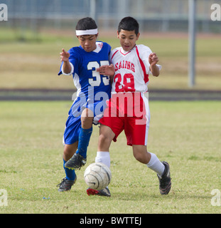 7. und 8. Klasse jungen im Alter von 13 und 14 Fußball spielen für ihre Schulteams in einem Ligaspiel in Austin, Texas Stockfoto