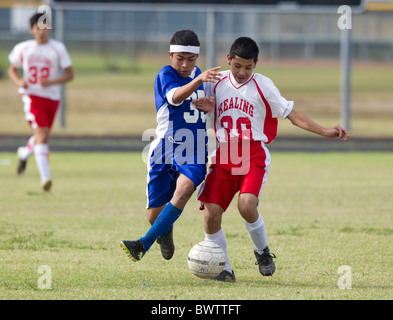 7. und 8. Klasse jungen im Alter von 13 und 14 Fußball spielen für ihre Schulteams in einem Ligaspiel in Austin, Texas Stockfoto