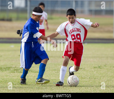 7. und 8. Klasse jungen im Alter von 13 und 14 Fußball spielen für ihre Schulteams in einem Ligaspiel in Austin, Texas Stockfoto