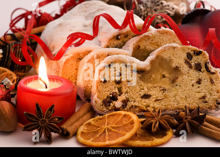 Weihnachts-Dekoration mit Marzipan Stollen und Kerzenlicht als Nahaufnahme Stockfoto