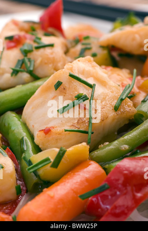 Thai Fisch mit Gemüse und Reis Nudeln als Closeup in einem weißen Teller Stockfoto