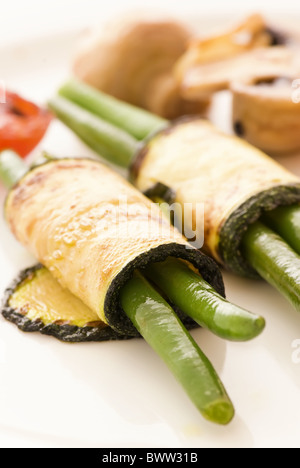 Bohnen in Auberginenscheiben als Closeup auf einem weißen Teller gerollt Stockfoto