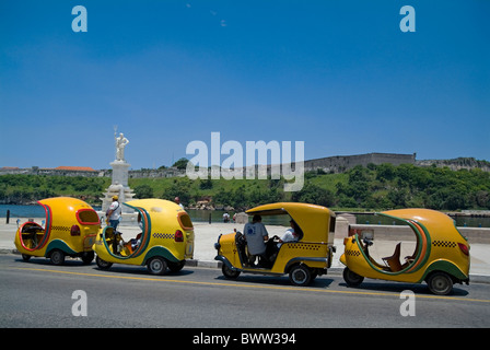 Coco Taxis in einer Linie an der Avenida del Puerto, Havanna, Kuba. Stockfoto