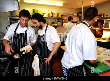 Chefkoch Stephen Terry (Mitte) zeigt die Färbung ein Stück Schweinefleisch von Chefkoch Ashley Wald bei The Hardwick Restaurant Ab Stockfoto