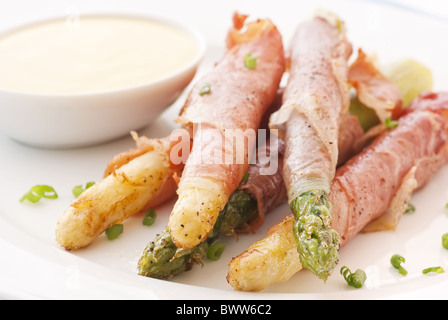 Grünen und weißen Spargel in Schinken und Aioli als Closeup gerollt Stockfoto