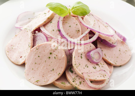 Bayerische Wurst Saland mit Zwiebelringen als Closeup auf weißen Teller Stockfoto