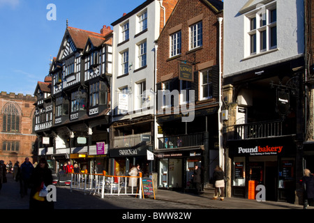 Chester gemauerte Kathedrale Stadtzentrum; die Reihen Fußgängerzone Straßen, Unternehmen, Geschäfte, Käufer, Galerien und Gebäude in Eastgate, Großbritannien Stockfoto