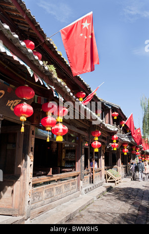 Rote Lampions und Fahnen außerhalb der traditionellen Altbau, Dayan Altstadt Lijiang, Yunnan Provinz, China Stockfoto