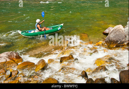 USA, Idaho, Menschen, die Middle Fork des Salmon River, reife Erwachsene Frau paddeln Rafting Kajak in der Nähe von plätschernden Wasserfall. Stockfoto