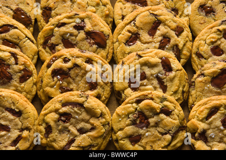 Chocolate Chip Cookies auf einem Holz-Tablett über eine braune Leinen-Serviette. Stockfoto