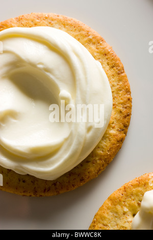 Kekse mit cremiger Käse verteilen auf oben auf einem weißen rechteckigen Teller. Stockfoto