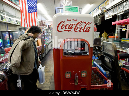 Kunden schaut einem 1940er-Jahre-Stil-Coca-Cola-Automaten zum Verkauf an einen Shop, spezialisiert auf Produkte von American Diner in Tokio Stockfoto