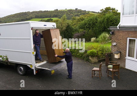 Zwei Männer, die ein Landhaus für eine Gemeinschaft Recyclingprojekt in Newtown Powys Mid Wales UK Möbel entfernen Stockfoto