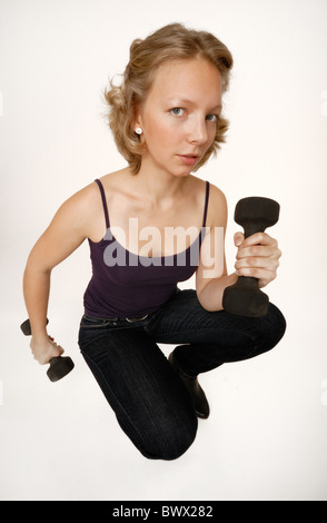 Junge Frau mit Hanteln, Kniebeugen, Lächeln, ein gutes Gefühl Stockfoto