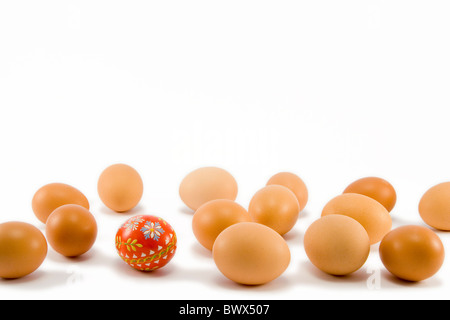 handgemalte rotes Ei unter natürlichen Eiern Stockfoto