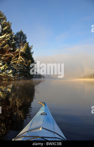 Kajakfahren auf den St. John River Anfang Dezember nach Neuschnee an einem frühen Morgen mit ruhigem, klarem Wasser Stockfoto