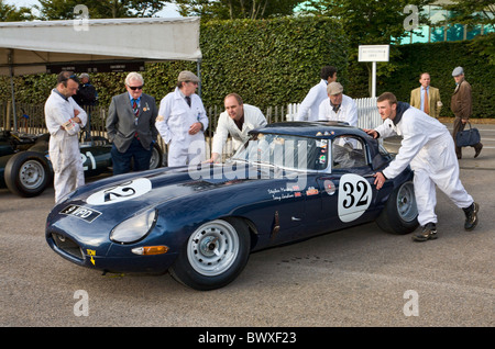 1961 Jaguar E-Type wird in das Fahrerlager von Mechanikern geschoben. 2010 beim Goodwood Revival Meeting, Sussex, England, UK. Stockfoto