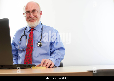 Arzt sitzt an seinem Schreibtisch Stockfoto