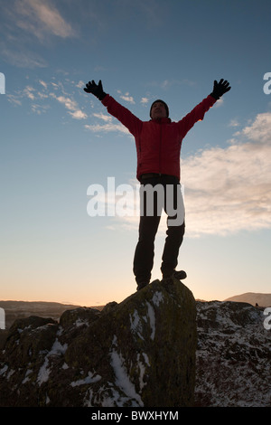 Ein Bergsteiger auf Todd Crag Gipfel im Lake District, Großbritannien, in der Dämmerung. Stockfoto