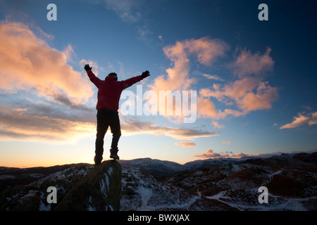 Ein Bergsteiger auf Todd Crag Gipfel im Lake District, Großbritannien, in der Dämmerung. Stockfoto