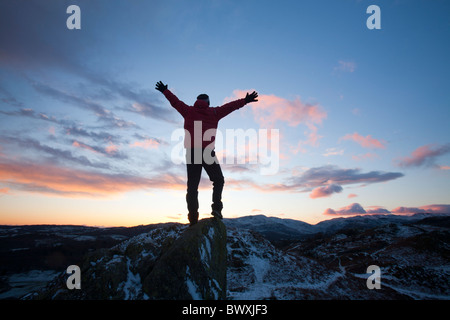 Ein Bergsteiger auf Todd Crag Gipfel im Lake District, Großbritannien, in der Dämmerung. Stockfoto