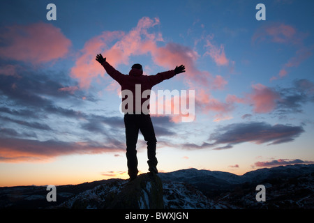 Ein Bergsteiger auf Todd Crag Gipfel im Lake District, Großbritannien, in der Dämmerung. Stockfoto