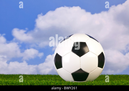 Foto von einem Fußball auf dem Rasen mit Himmelshintergrund. Stockfoto
