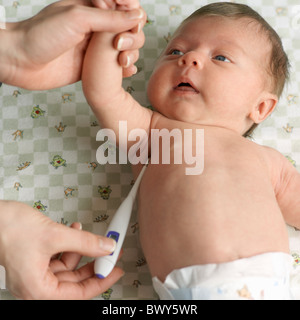 Frau, die Temperatur des Babys mit Digitalthermometer Stockfoto