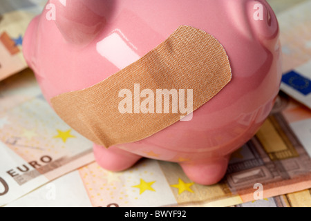 Heftpflaster auf rosa Piggy Bank 50 Euro-Banknoten Stockfoto