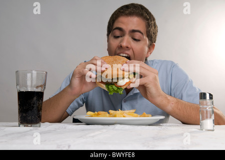 Mann isst einen Hamburger mit Pommes frites Stockfoto