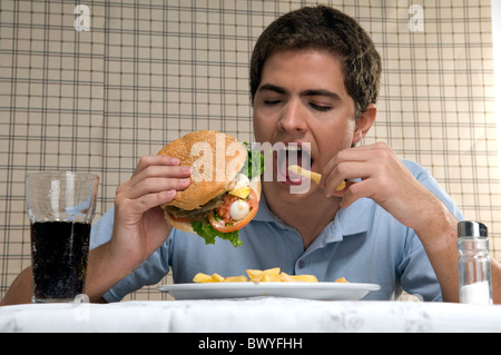 Mann isst einen Hamburger mit Pommes frites Stockfoto