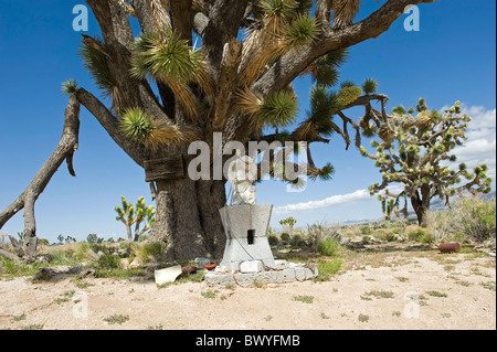 Geflügelte Engel geschnitzt aus Stein mit der Halskette verziert und andere Gegenstände, die am Straßenrand in der Nähe von Joshua Bäume zu beten. Stockfoto