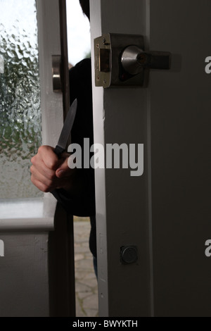 Abbildung der männlichen Hand mit einem Messer eine Haustür betreten Stockfoto