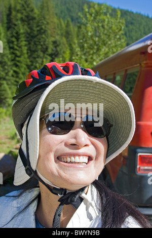 Frau trägt Fahrradhelm über Diskette Sonnenhut bereitet sich auf die Hiawatha Ausritt in Idaho, USA. Stockfoto