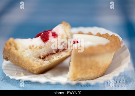 In zwei kleinen Bakewell Kuchen schneiden Stockfoto