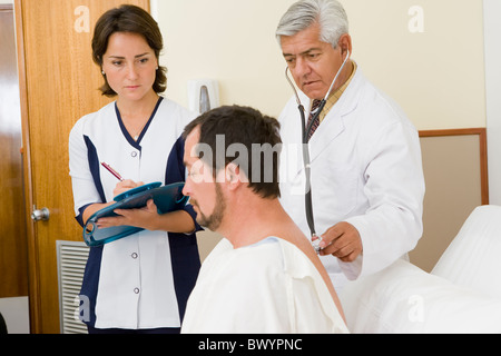 Arzt und Krankenschwester untersuchen Patienten im Krankenzimmer Stockfoto