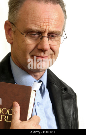 November 2005 - der reife Vikar hält seine bibel Stockfoto