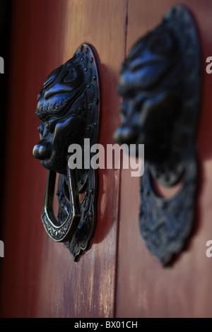 Lion geformte Griffe auf dem Tor ein Hutong Hofhaus, Peking, China Stockfoto