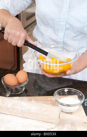 Eine Frau mischt den Pfirsich-Füllung für eine Torte, die sie die Backen. Stockfoto
