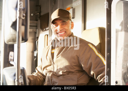 Lächelnder Hispanic Lieferung Mann sitzen im LKW Stockfoto