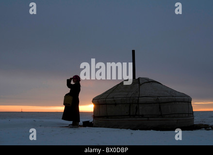 Mongolische Frau vor einer Jurte im Sonnenuntergang, Hulun Buir Grünland, Manzhouli, Hulunbuir, Innere Mongolei, China Stockfoto