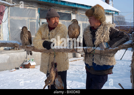 Zwei Manchurian Jäger und ihre Gerfalke, Adler Dorf, Changyi, Jilin, Jilin Province, China Stockfoto