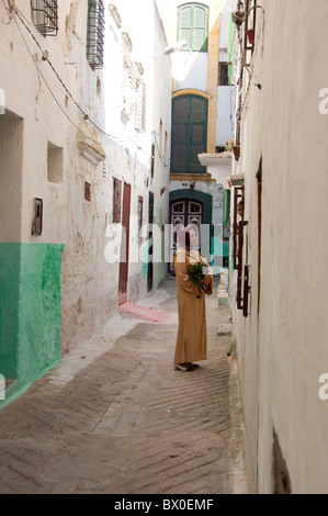 Marokko, Tetouan. Die Medina (Altstadt) von Tétouan, UNESCO. Frau in traditioneller Kleidung in typischen schmalen Gasse. Stockfoto