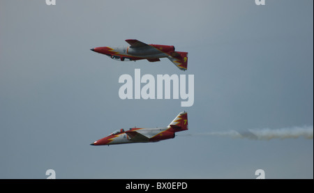 Zwei spanische Kunstflugstaffel Air Force Flugzeuge Aguilla Casa 101 Aviojet spiegeln einander fliegen entlang parallel - ein invertieren Stockfoto