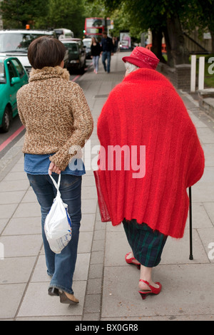 Stilvolle Rentner in ihrem rot gefärbt koordinierten Hut, Mantel und Schuhe schlendern Londoner St Johns Wood. DAVID MANSELL Stockfoto