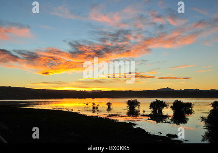 Blauer Himmel orange Wolken Sonnenuntergang Reflexion in den Gewässern von Bahia Redonda, Blick in Richtung Andengipfel, El Calafate in Patagonien Stockfoto